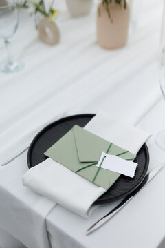 Letter, napkin on plate and knife on modern decorated table