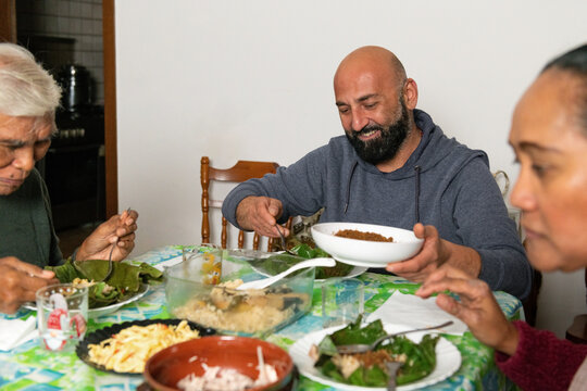 Smiling Family eating together to share a traditional meal at home