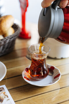 Pouring hot tea into a traditional Turkish glass 