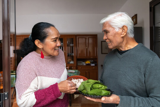 Father and daughter chatting while holding food at home
