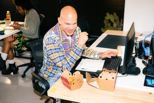 Man enjoying delivered food while working at office 