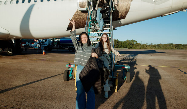 Women Getting Off The Plane at an Airport in Daylight