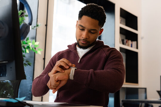 Man checking notifications on smartwatch at office 