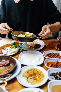 Person serving eggs during traditional Turkish breakfast