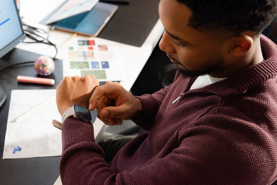 Man Checking Smart Watch During Work in Office