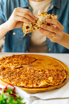Person eating folded lahmacun with salad
