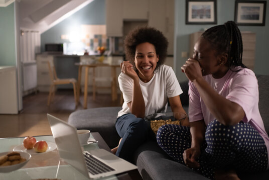 Laughing diverse multiracial women watching comedy having pajama party
