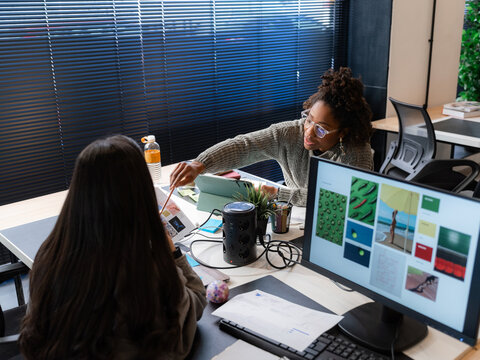 Professionals discussing design at office 