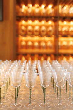 Rows of elegant champagne or wine glasses on table in blurred room