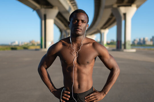 Muscular sportsman standing with hands on hips