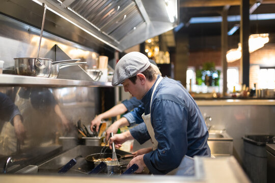 Man cooking sauce in restaurant kitchen