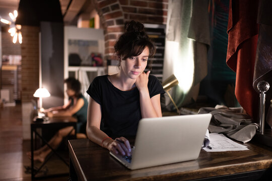 Smart female designer using laptop in studio
