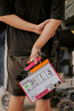 Film crew member holding a clapperboard on set