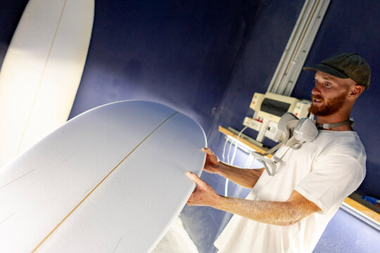 Surfboard shaper inspecting asymmetrical tail in Australia