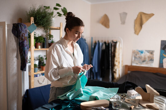 Young woman sewing in home atelier