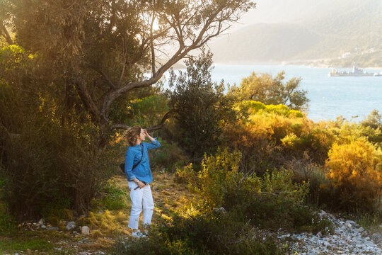 Woman standing in coastal forest clearing