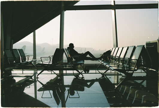 Travelers wait at an airport in the early morning light