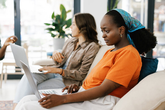 Young Women Work Together in a Modern Cafe During the Day