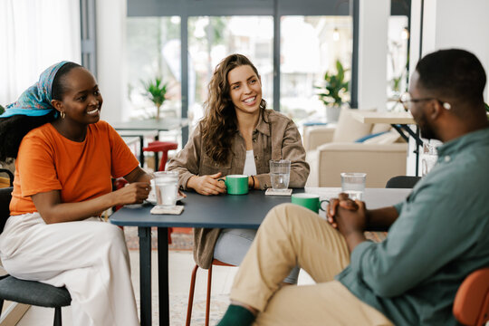 Friends Enjoy Drinks and Conversation in a Cafe Setting