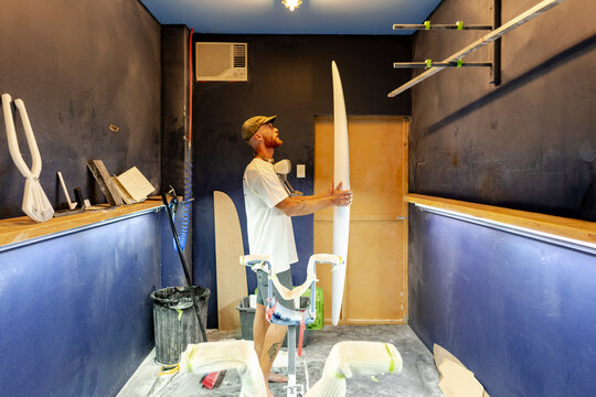 Surfboard shaper inspecting outline in Australia