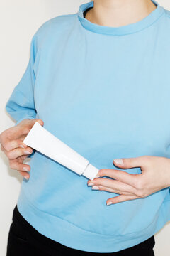 Person holding beauty plastic product tube container with flashlight