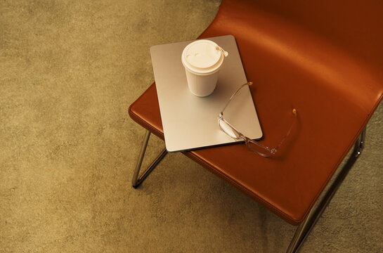 Coffee cup and glasses on a table in a simple room with light carpet