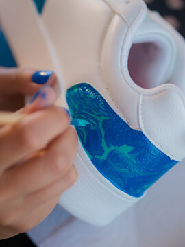 Designer customizing white sneaker 
