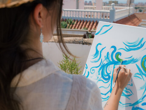 Woman Paints on Canvas At Sunny Terrace