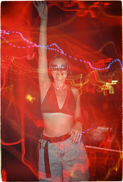 Woman dances at a party with colorful lights in an indoor venue