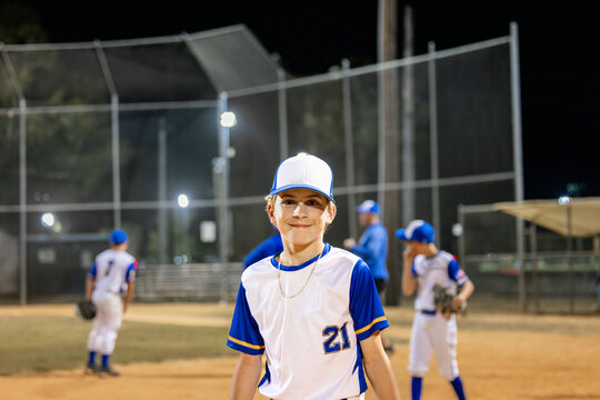 A Young Player Stands on the Baseball Diamond at Night