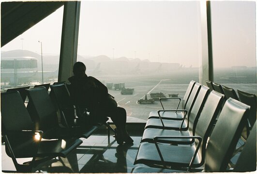 Woman sits alone in airport waiting area early in the morning