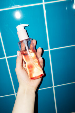 Pink coral beauty product on a pump bottle in bathroom with flashlight