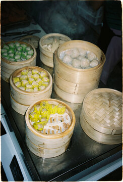 Dumplings steaming in bamboo baskets at a food stall