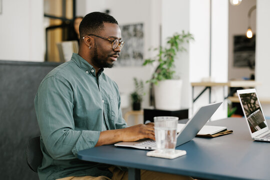 Man Works on Laptop in Modern Office Space 