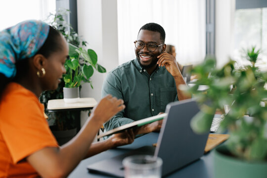 Two People Discuss Ideas During a Meeting in a Bright Office