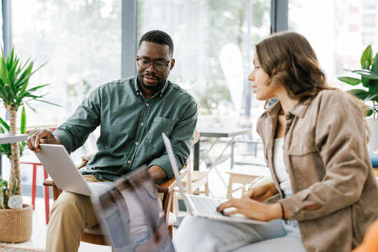 Two Young People Working Together in Bright Office Space