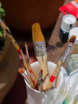 Paintbrushes in cup on table 