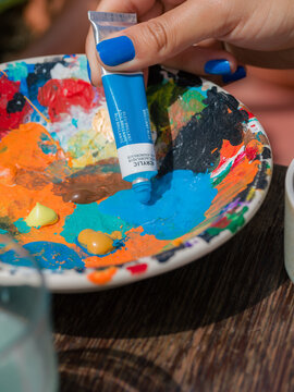 Painter squeezing paint on palette