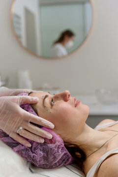 Woman preparing for facial injection procedure in beauty clinc