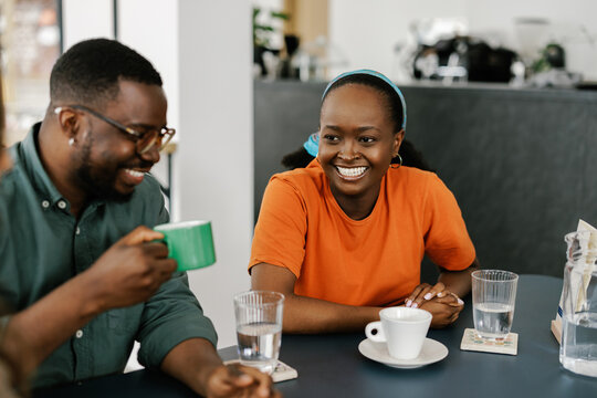 Friends Enjoy Drinks and Conversation in a Cafe Setting