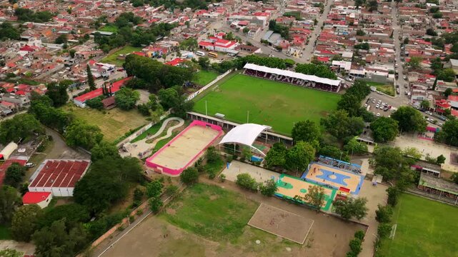 Aerial view of Estadio Municipal de Tuxpan Jalisco featuring the green soccer pitch and surrounding sports courts in Tuxpan, Jalisco, Mexico.