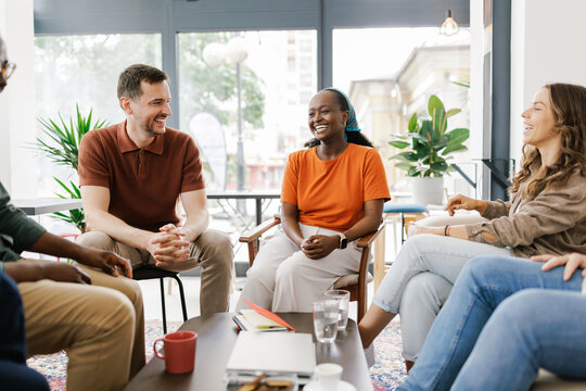 Group of People Talking and Laughing in a Bright Room
