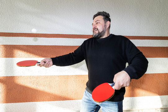A man with a racket hits a ball.