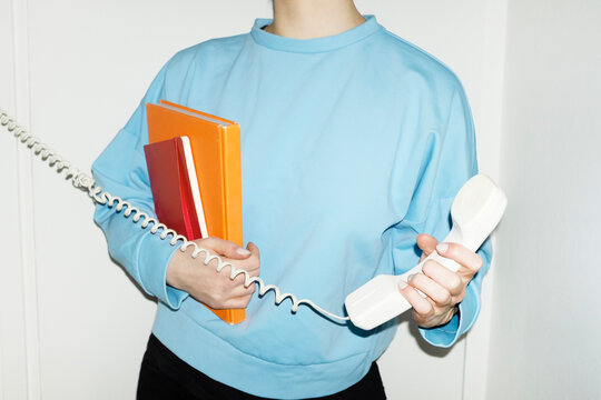 Person answering speaking to landline wire phone in work office 