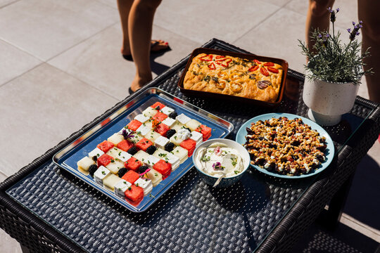 Summertime snacks - focaccia, fruits, nuts and hummus arranged