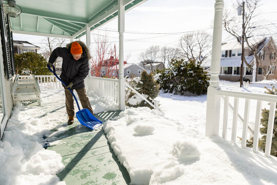 Senior man snow shovel porch home