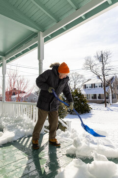 Portrait senior man snowstorm shovel porch home