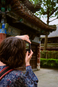 Traveler Takes Picture in Historical Courtyard During Daytime