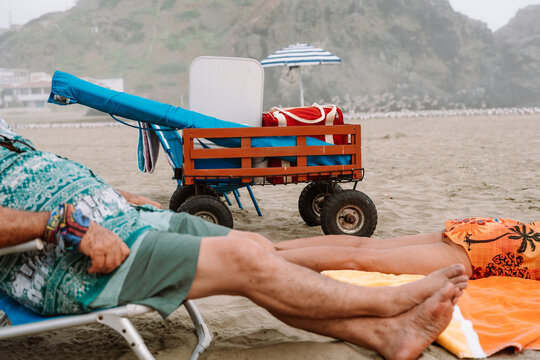 Mature man and woman Napping on Beach on Cloudy Day