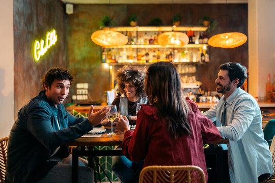 Friends enjoying dinner and drinks in restaurant
